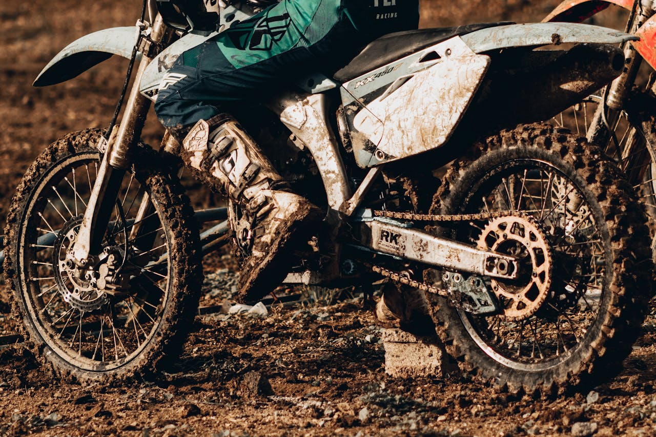 Close-up of motocross rider navigating rough, muddy terrain, showcasing grit and adventure.